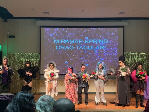 (From left to right)  Host Carlos Trujillo stands with performers Sienna Desire, Vanity Jones, Sister Develyn Angels, Rudy, Mercury Dee, Barbie Z, and Delicious Jones, as they accept flowers as a gift from Miramars LGBTQ+ Alliance. 