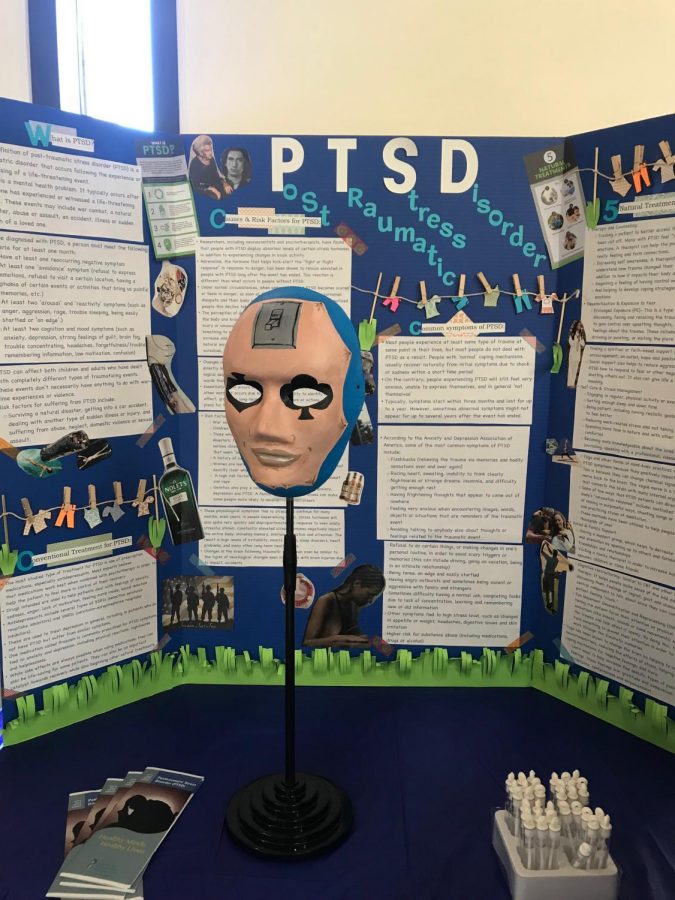 Business administration 
student Vantha Saos art presentation on post-traumatic stress disorder features a poker face mask.
