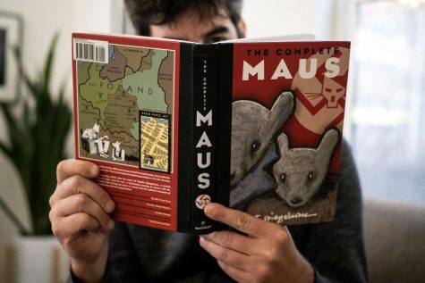 This illustration photo taken in Los Angeles on Jan. 27, 2022, shows a person holding the graphic novel Maus by Art Spiegelman. A school board in Tennessee has added to a surge in book bans