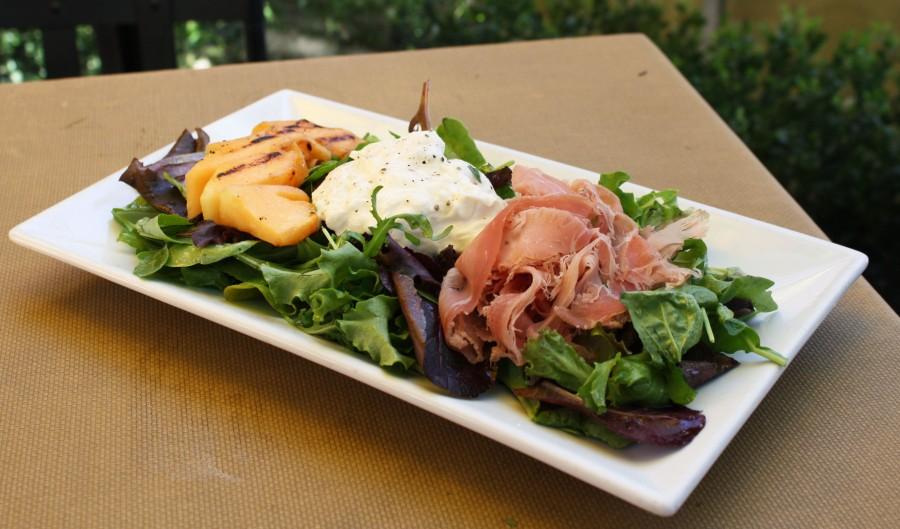 The flavoral and refreshing grilled cantaloupe salad combines the sweet melon with creamy burrata cheese and salty prosciutto atop a bed of mixed greens. [Photo Credit: Lauren J. Mapp]