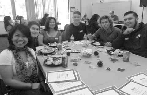 Students and their families enjoying food and table games.
Photo Credit: Ashanti Hands