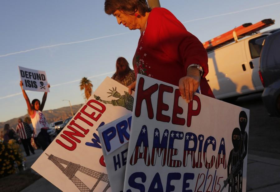 President Obama is scheduled to make a stop on Friday, Dec. 18, 2015, in San Bernardino, Calif., to privately visit the families of some of the victims of the December 2nd terrorist attack. Protesters took to street corners to voice their opposition to both Obama and ISIS, including anti-Obama protester Deann DLean, right, in San Bernardino on Friday evening. (Michael Robinson Chavez/Los Angeles Times/TNS)