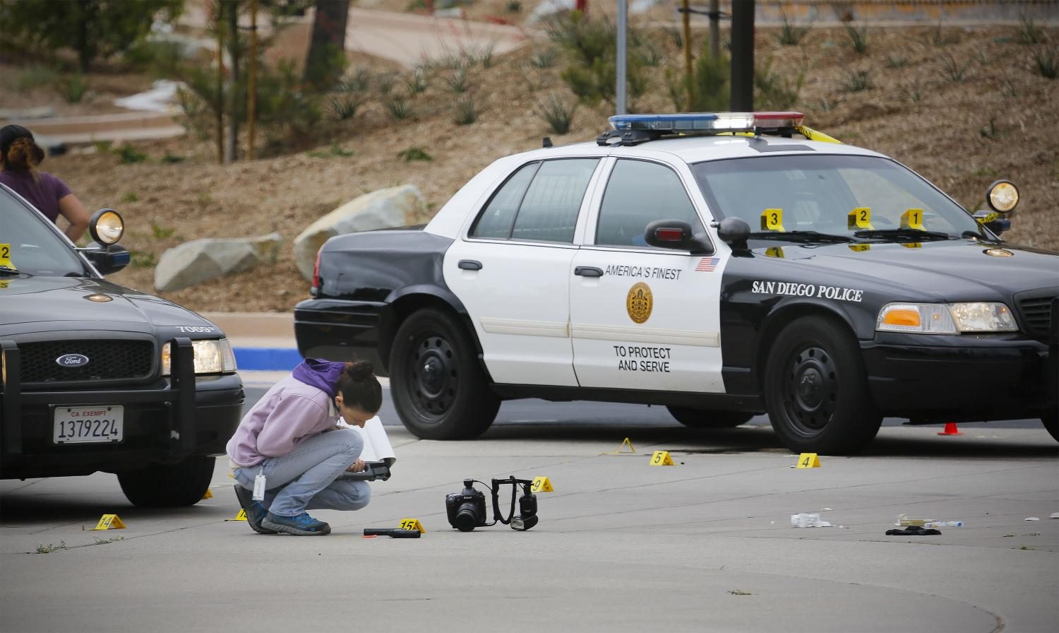 A member of the San Diego Police Department examines what appears to be a gun on the ground at the scene of a fatal police officer involved shooting of a 15-year-old boy in one of the parking lots in front of Torrey Pines High School, early Saturday morning, May 6, 2017, in San Diego, Calif. Police believe the boy called police, and when they arrived pointed a gun at them and didn't follow their commands to drop it. It turns out that the gun is a semi-automatic BB air pistol. (Howard Lipin/San Diego Union-Tribune/TNS)