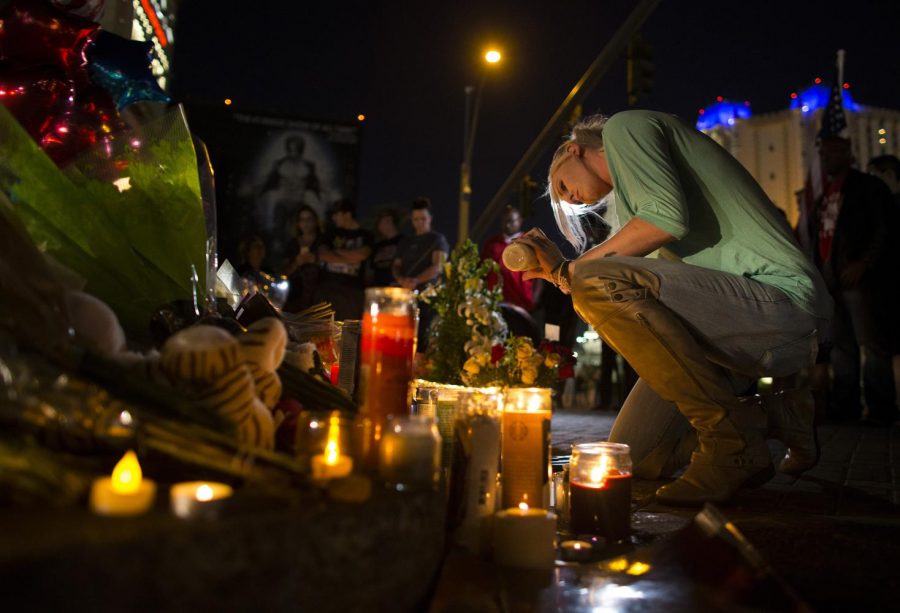 Kaili Berdge of Scottsdale, Ariz. makes sure every candle stays lit Wednesday, Oct. 4, 2017 at a memorial for the victims of the mass shooting near the crime scene off Las Vegas Boulevard in Las Vegas, Nev. (Gina Ferazzi/Los Angeles Times/TNS)