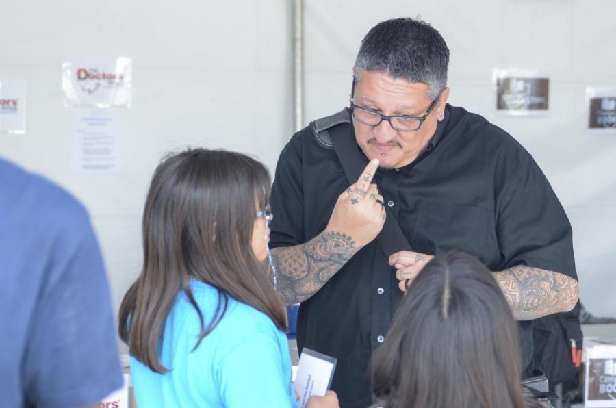 A man having a conversation with a young girl in sign language.