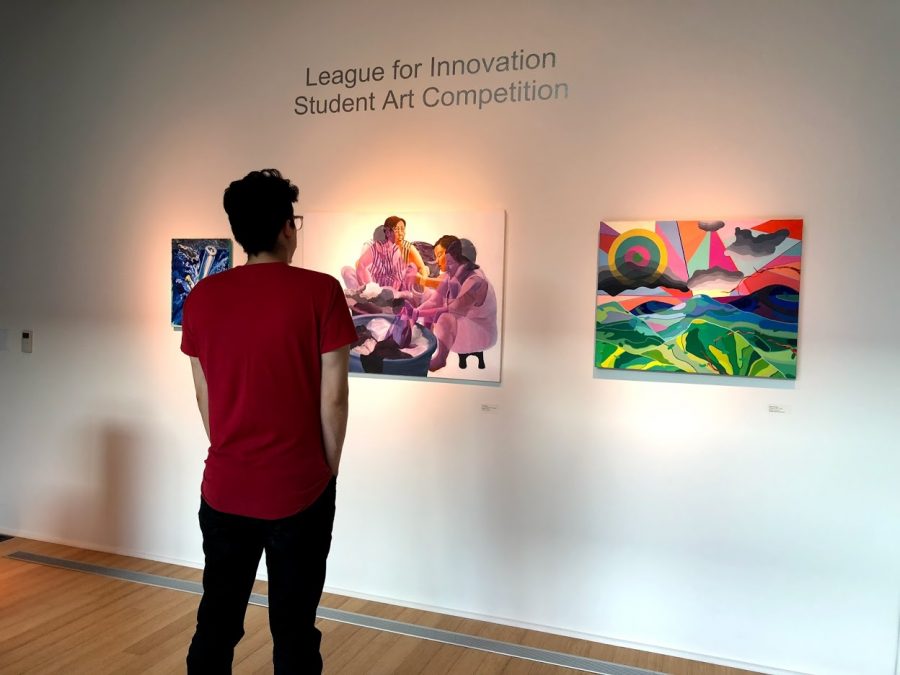 A man who attended the show admiring a piece by artist Jenny Tran. 