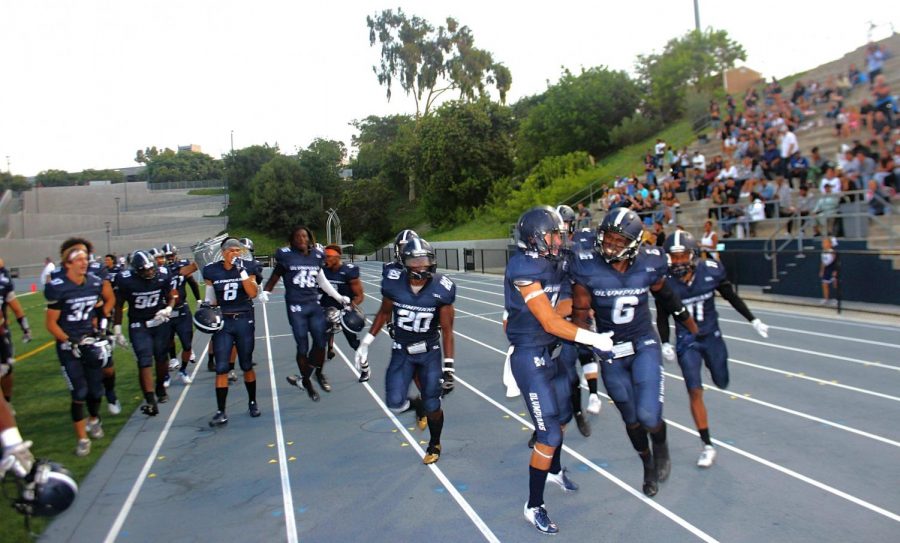 Team celebrates after LB Reginald Prince (#6) returns an interception for a touchdown in 40-14 Homecoming win. 