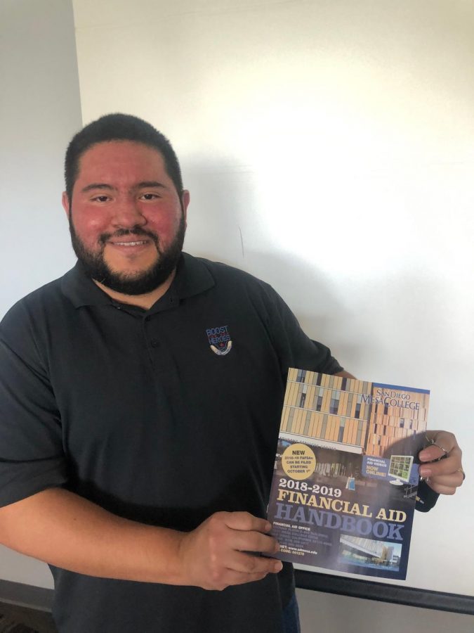 Felipe Arevalo showing off the Mesa College financial aid handbook after his presentation. 
