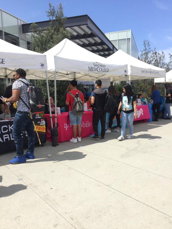 Students stop by the Chicken Charlie's, T-mobile, and Lyft booth at the job fair