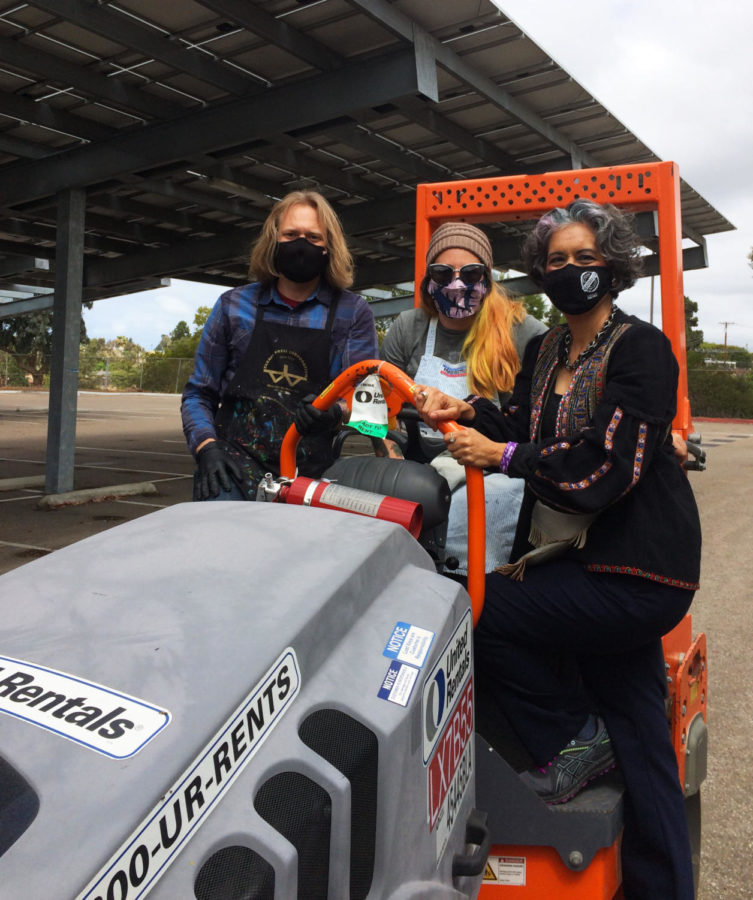 Chris Lahti, Jenny Armer and Alessandra Moctezuma pose on a steamroller during printing day for an upcoming exhibition.