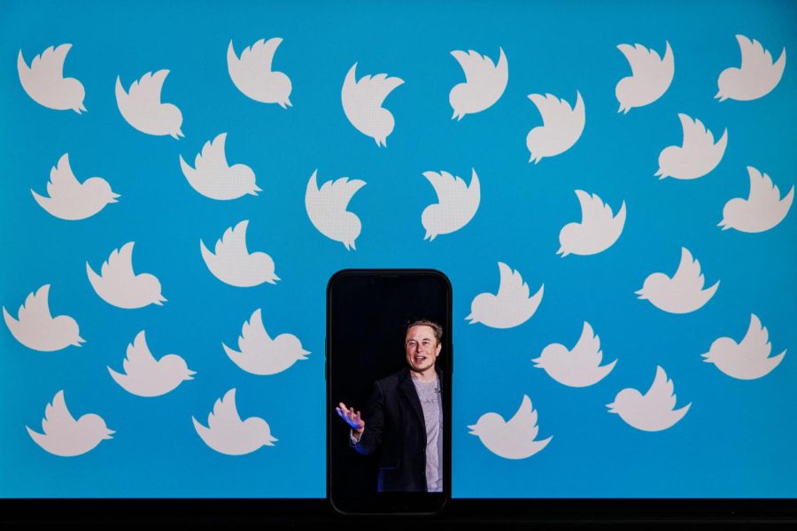 This illustration photo taken on Aug. 5, 2022, shows a cellphone displaying a photo of Elon Musk placed on a computer monitor filled with Twitter logos in Washington, D.C.