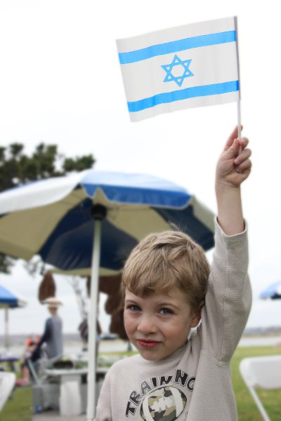 A Jewish boy waves an Israeli flag at an Israel Independence Day celebration in San Diego.